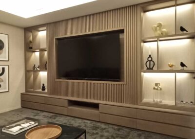 Salón con TV estilo clásico moderno con tonos neutros y madera.