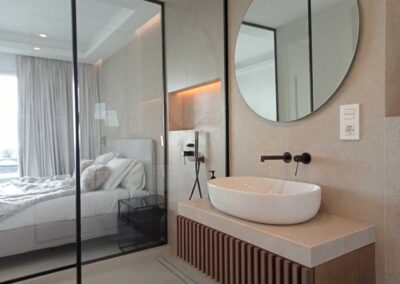 Baño minimalista con cristalera decorado con tonos neutros.