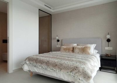 Dormitorio estilo minimalista, decorado con tonos gris y neutros.