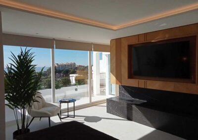 Salón minimalista con TV. En tonos madera, negro y blanco.