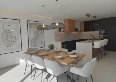 Cocina comedor con isla, decorado con tonos blanco, negro y madera.