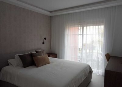 Dormitorio decorado en tonos tierra con balcón.