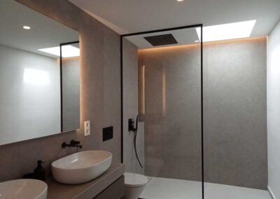 Baño con ducha en tonos blanco, gris y negro.